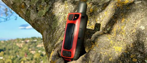 A close up of the Garmin GPSMAP 67i sitting on a tree